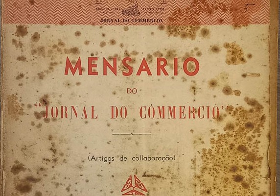 Na imagem conta uma frangmento da capa de um dos volumes do Mensario do Jornal do Commercio . Consta o título do Mensario em letras vermelhas e papel já amarelado com manchas do tempo.
